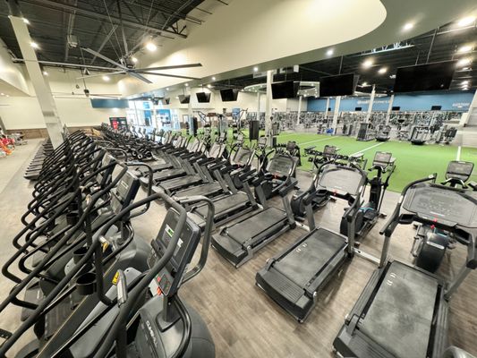Weight machines and benches neatly arranged in an Onelife Fitness strength training area.